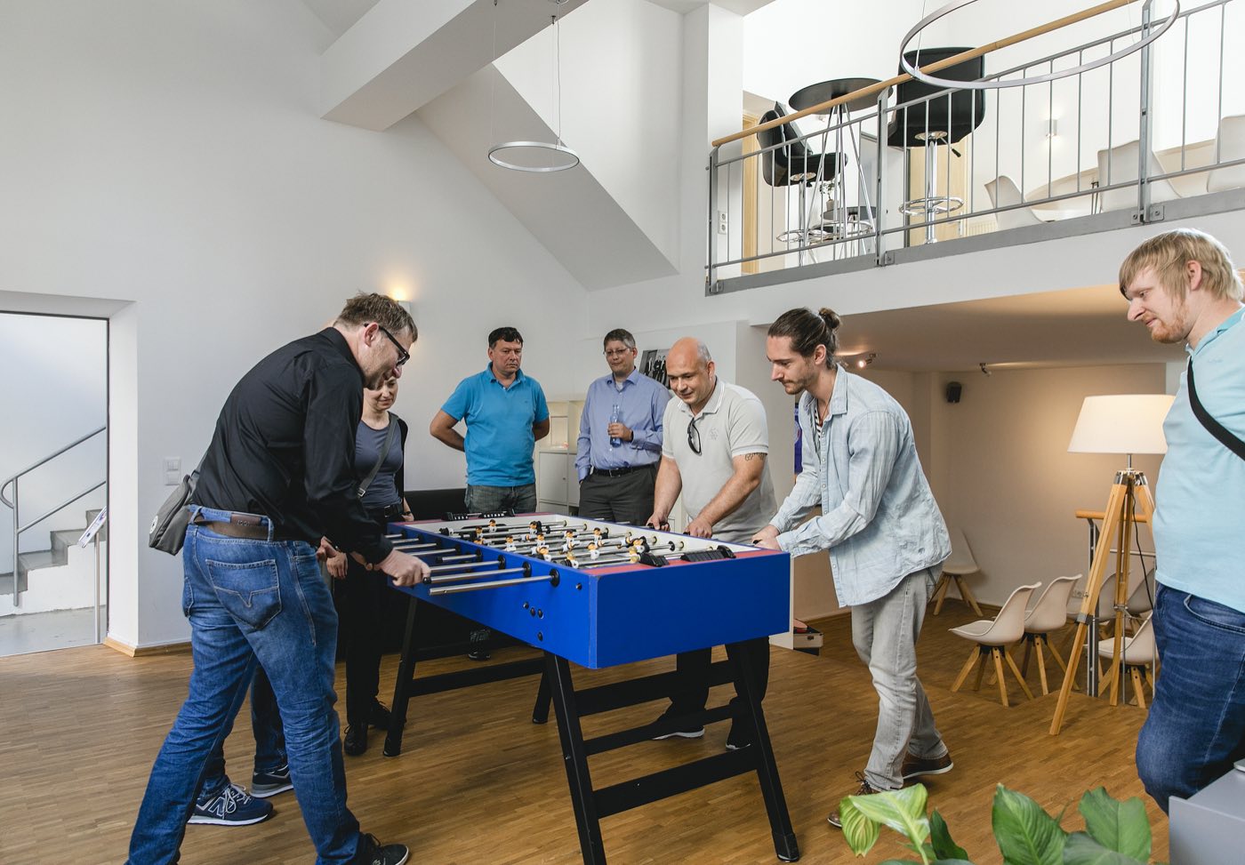 Gruppe spielt am Kicker im Eingangsbereich von Loft 18
