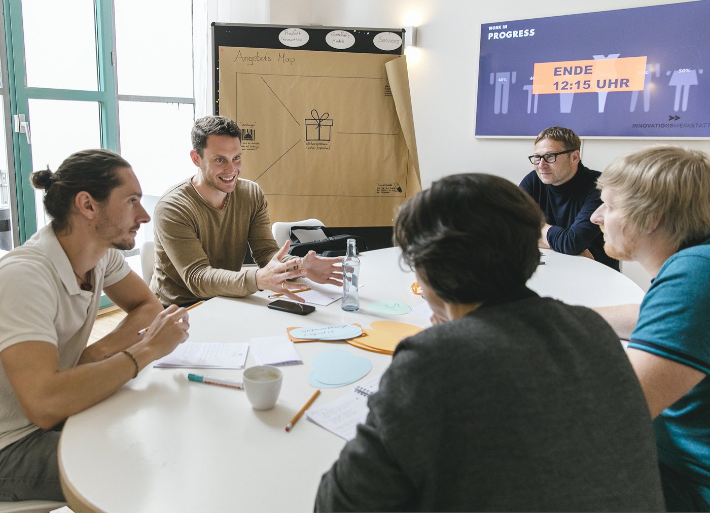 Gruppe arbeitet am großen Tisch mit Moderationskarten im 1. Stock