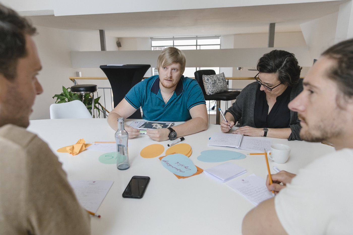 Teilnehmende arbeiten mit Laptops am großen Tisch im 1. Stock