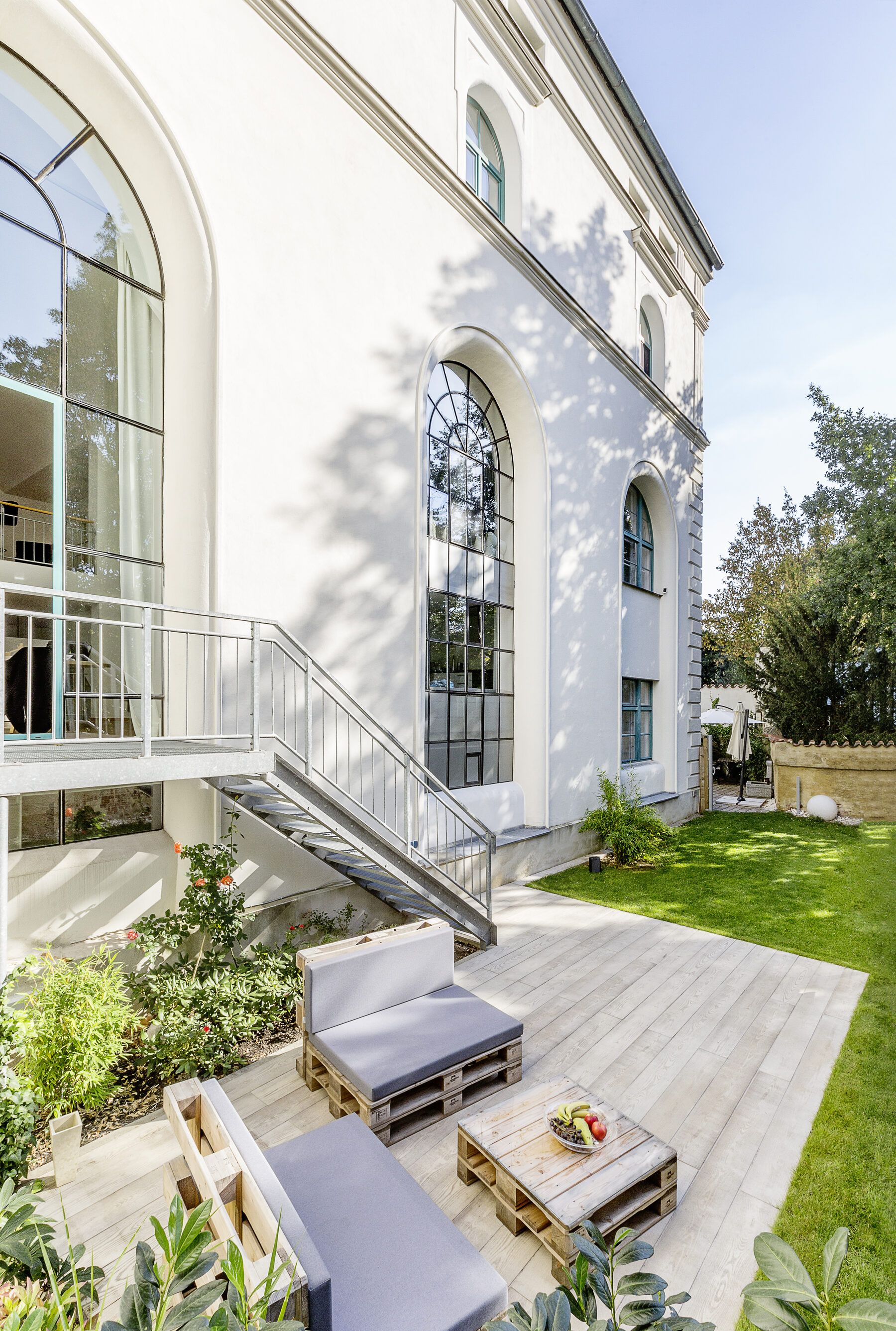 Weiter Blick über die Gartenterrasse von Loft 18 mit Freitreppe und Lounge-Möbeln