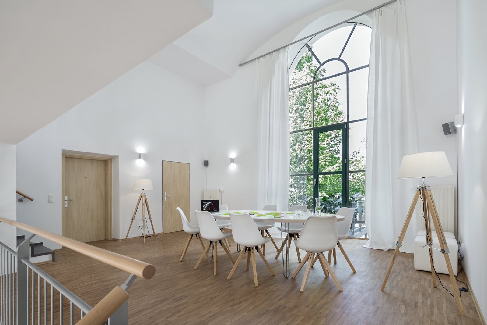 Langer Tisch unter dem großen Rundbogenfenster von Loft 18