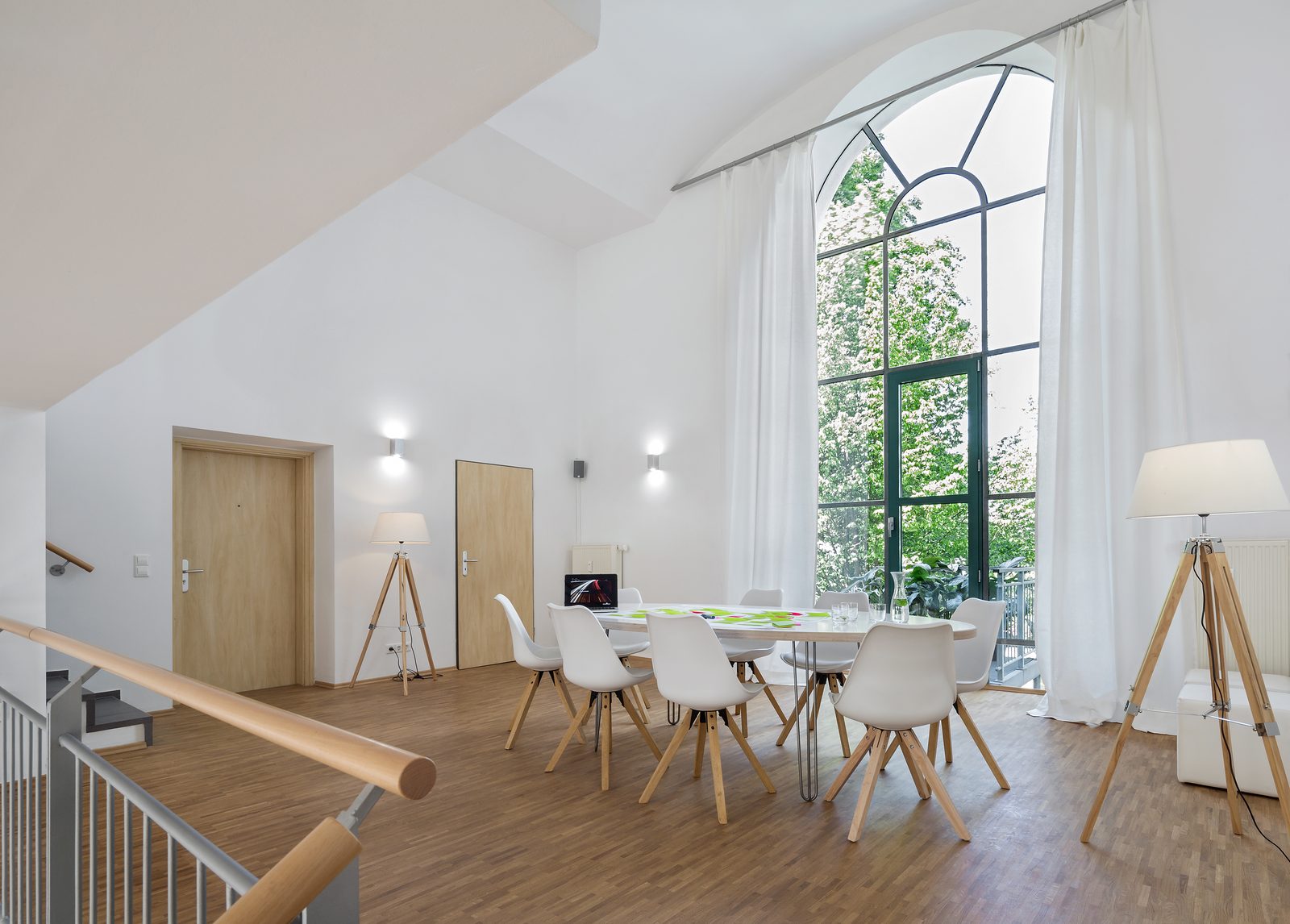 Blick durch das hohe Fenster in den Garten von Loft 18